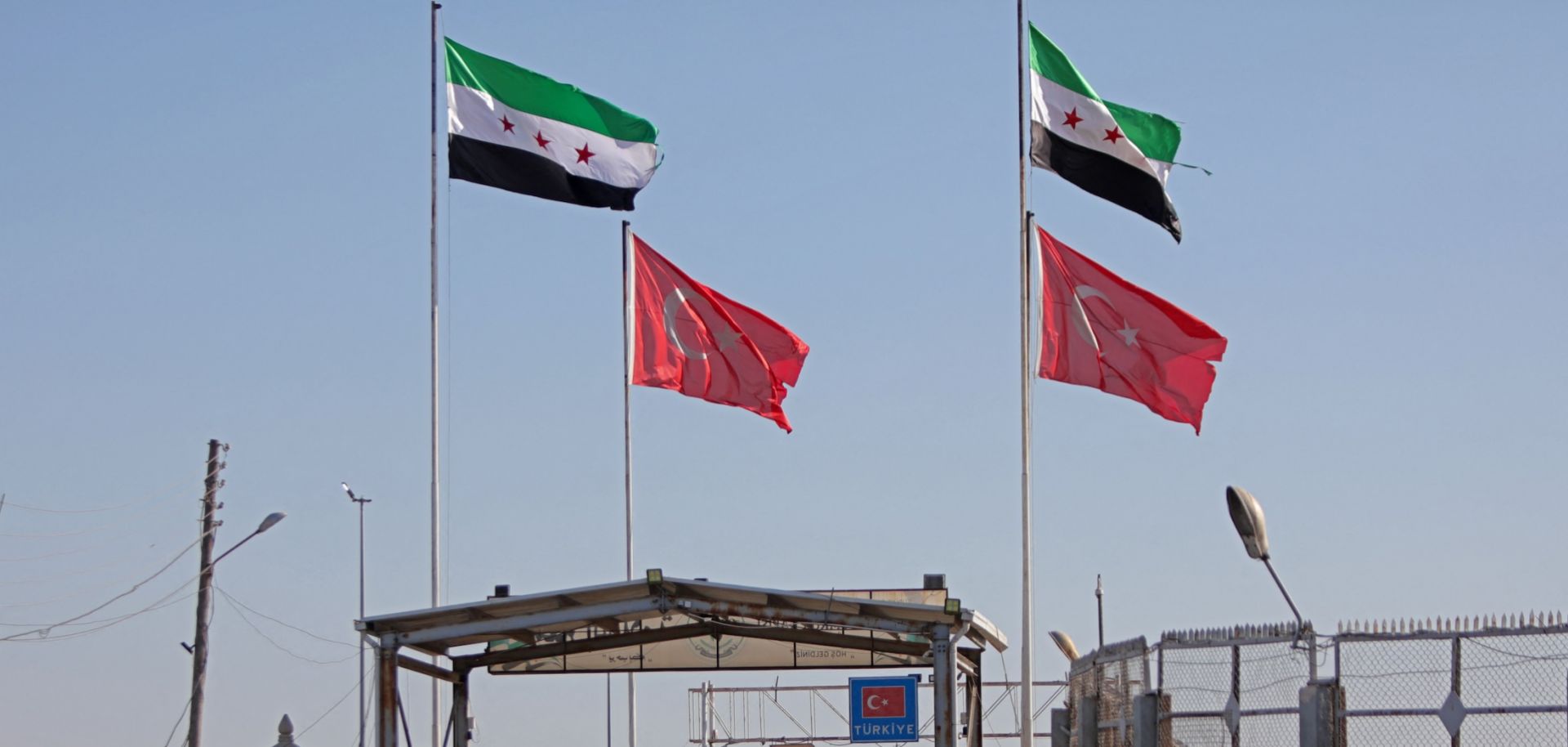 Turkish and Syrian flags wave above Syria's al-Salameh border crossing with Turkey on Aug. 27, 2023. 