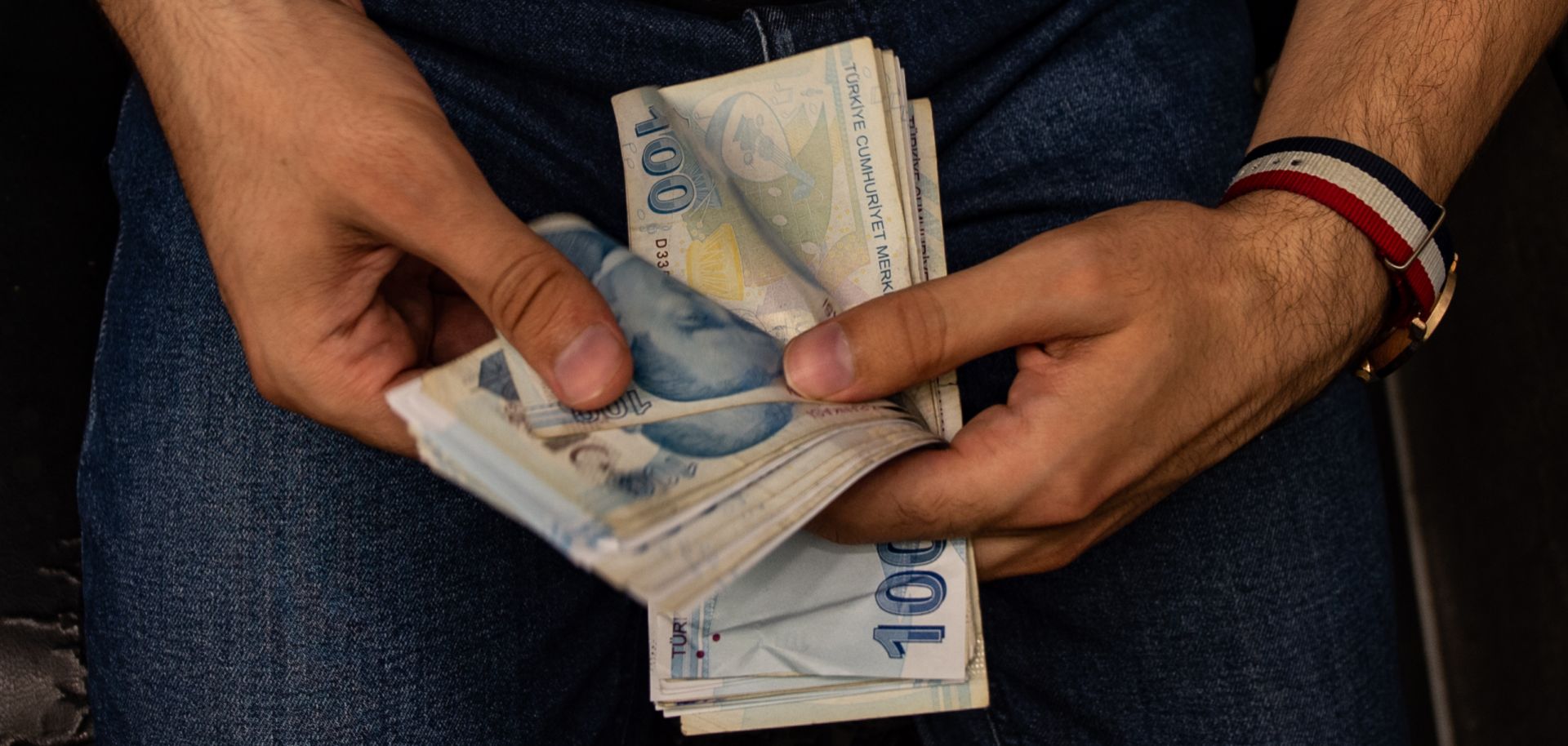 A currency exchange worker counts lira banknotes in Istanbul, Turkey, on Aug. 6, 2020.