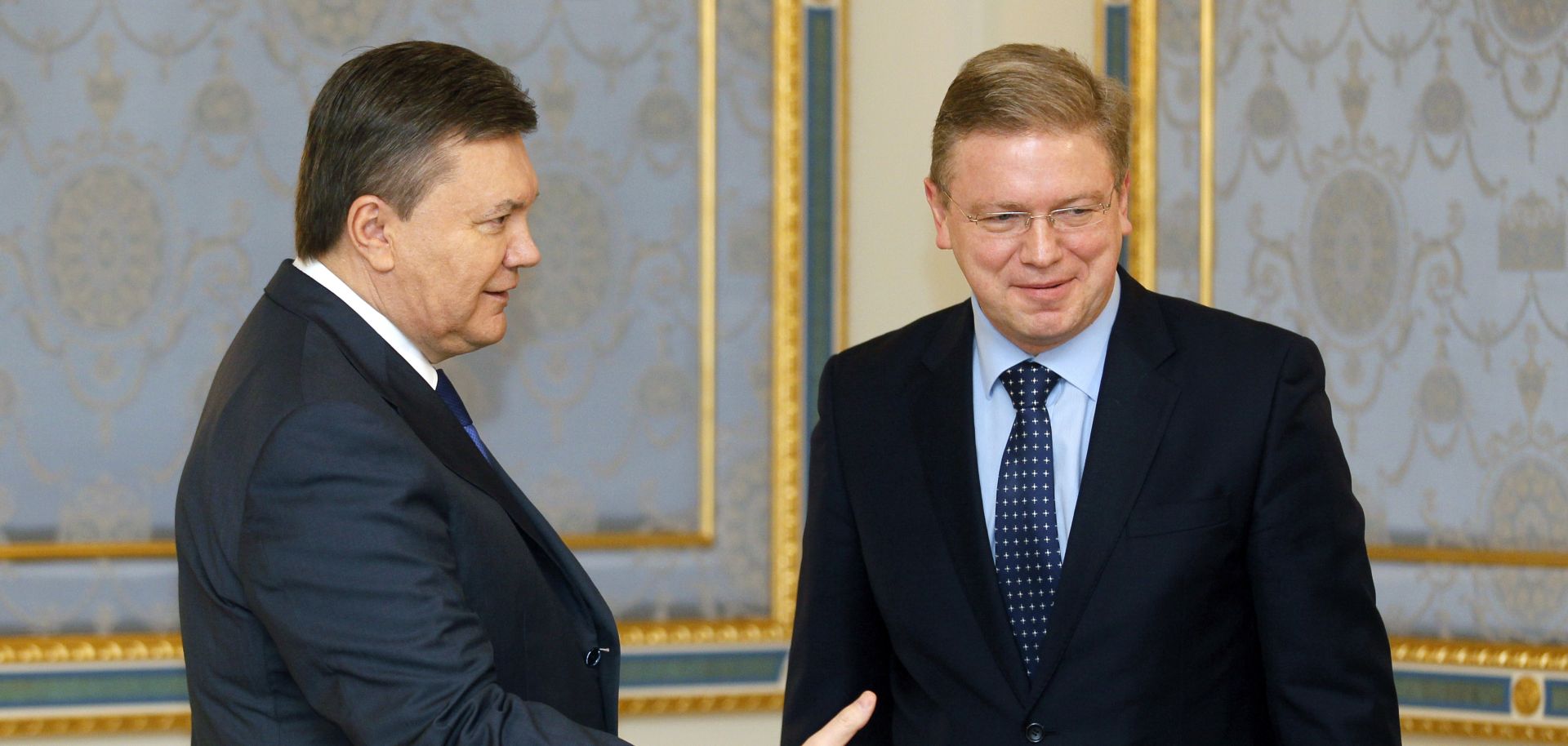 Ukrainian President Viktor Yanukovych (L) welcomes European Commissioner for Enlargement and European Neighborhood Policy Stefan Fuele prior their talks in Kiev on February 8, 2013.