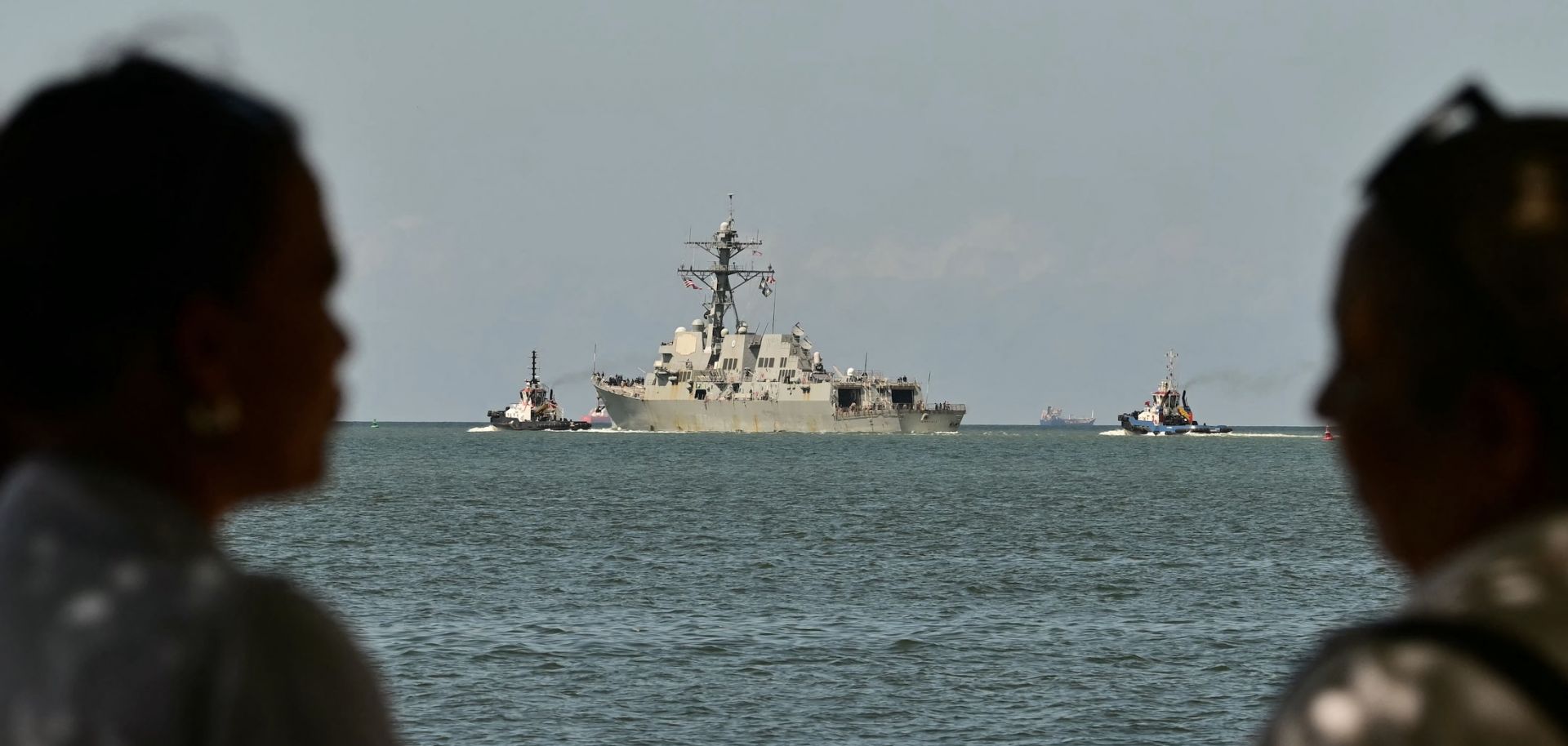 People watch the USS Gravely, a Navy warship, departing the Port of Spain on Oct. 30, 2025. The U.S. warship arrived in Trinidad and Tobago on Oct. 26, 2025, for joint exercises near the coast of Venezuela, as Washington ratcheted up pressure on drug traffickers and Venezuelan leader Nicolas Maduro.