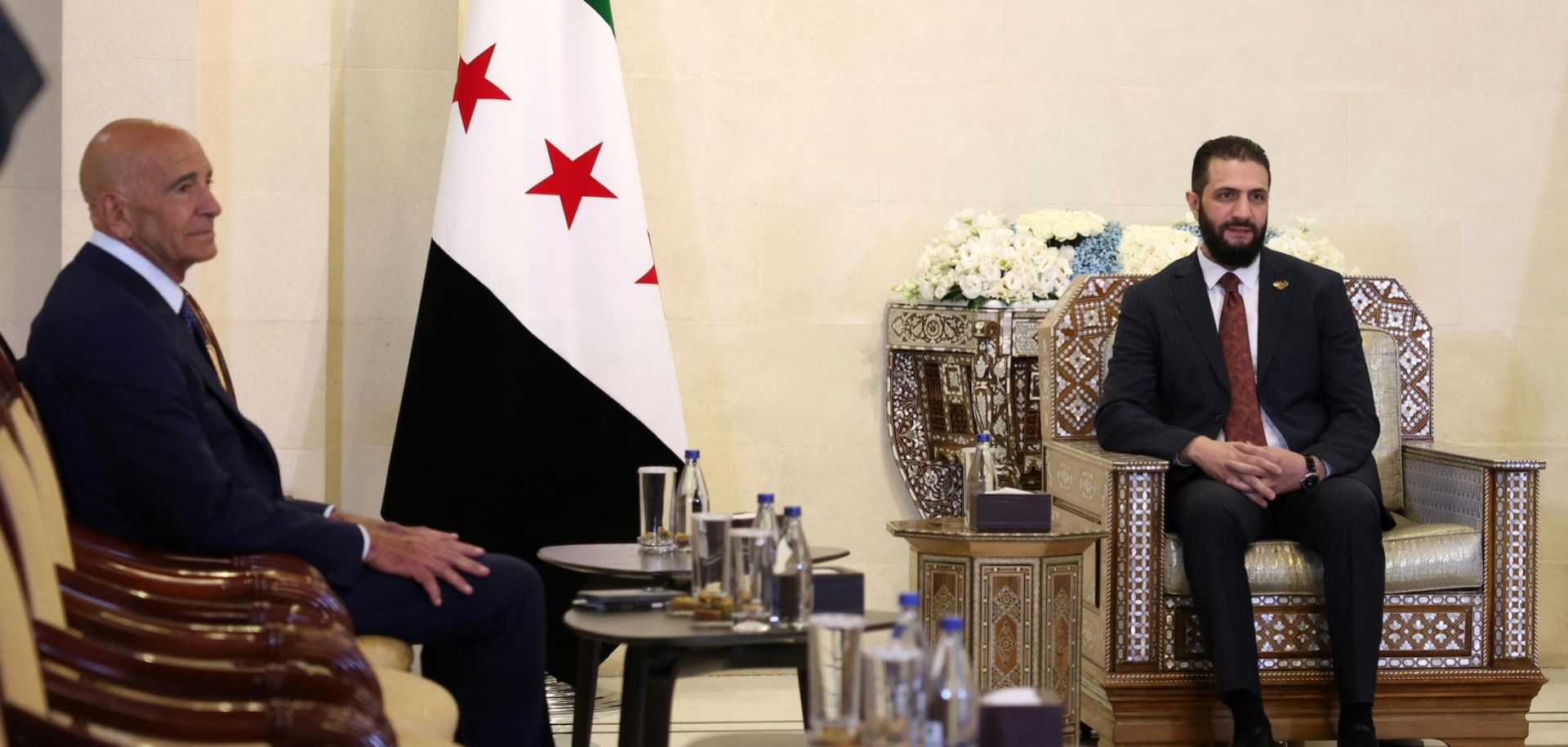 Syria's interim President Ahmad al-Sharaa (right) meets with U.S. envoy to Syria, Tom Barrack, at the presidential palace in Damascus on July 9, 2025. 
