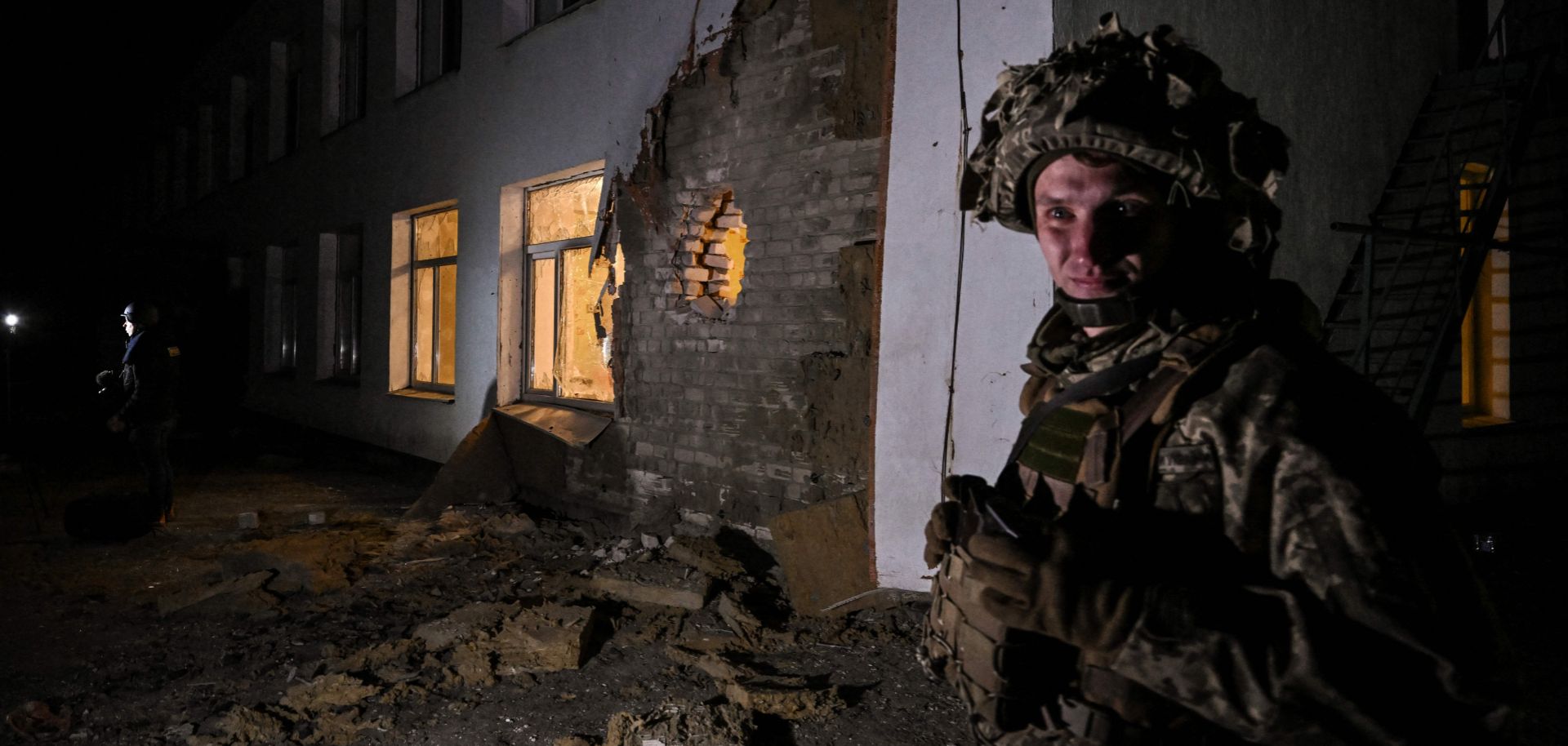 A Ukrainian soldier stands guard near debris after the reported shelling of a kindergarten in the settlement of Stanytsia Luhanska in eastern Ukraine on Feb. 17, 2022. 