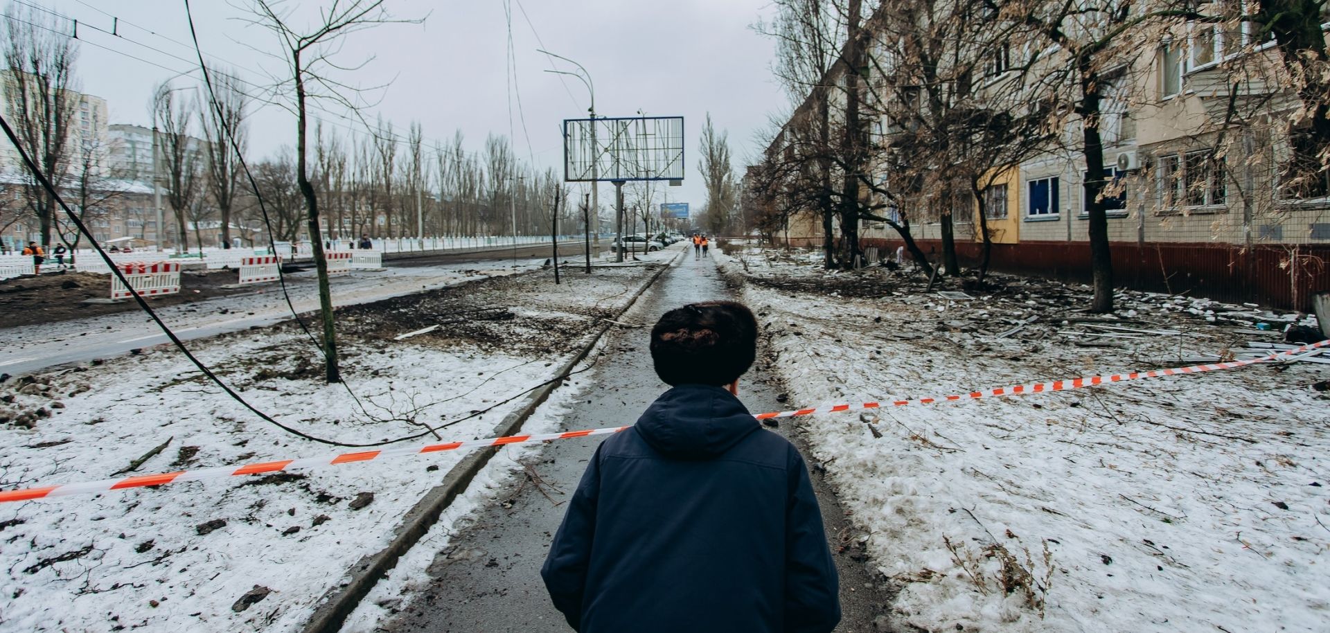 A man looks at the road blocked by striped tape on December 13, 2023, in Kyiv, Ukraine, following two nights of ballistic missile attacks on the city.