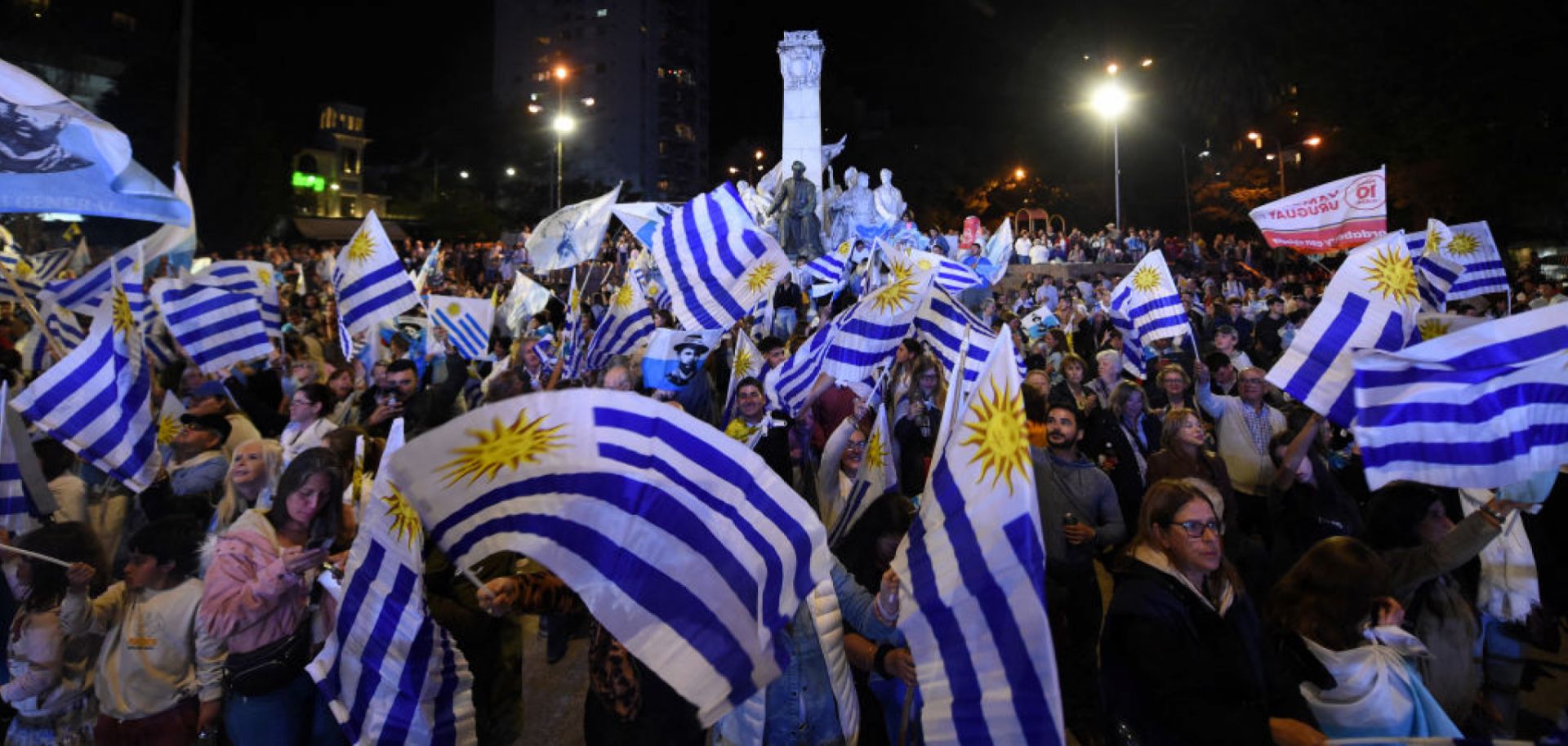 People wave Uruguayan flags after the first results of the presidential and legislative elections were announced, at Plaza Varela Square in Montevideo on Oct. 27, 2024. 