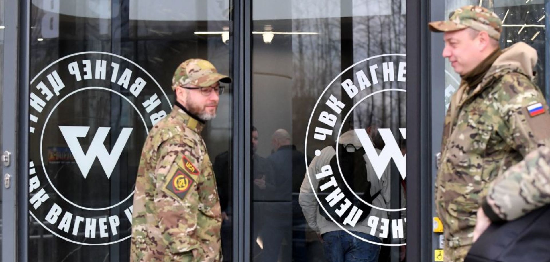 Visitors wearing military camouflage stand at the entrance of the ''PMC Wagner Center,'' which is associated with the founder of the Wagner private military group (PMC), Yevgeny Prigozhin, in Saint Petersburg, Russia, on Nov. 4, 2022.