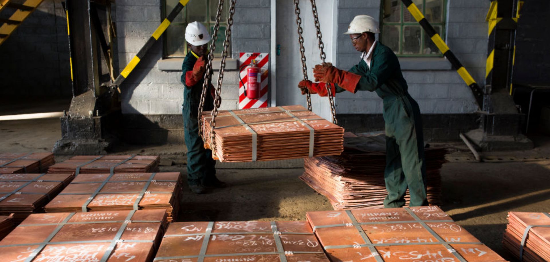 Workers move batches of copper sheets on July 6, 2016, in Mufulira, Zambia.