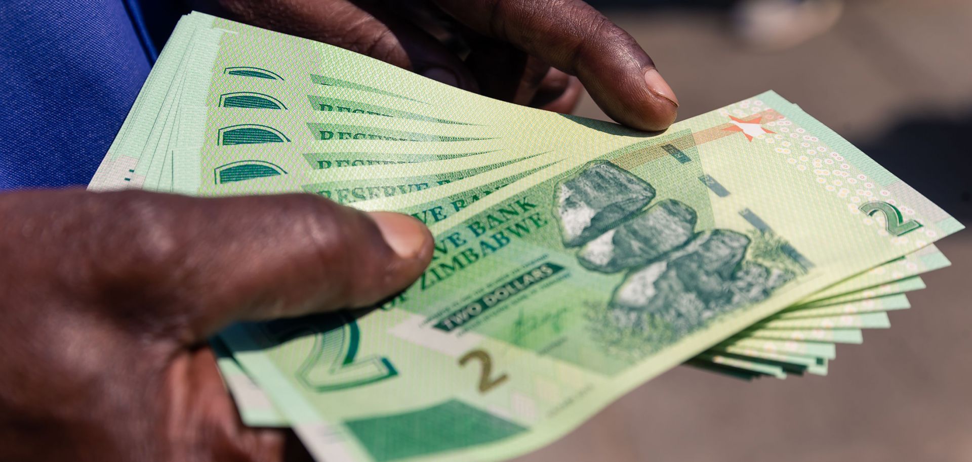 A man displays his new two-dollar notes of the Zimbabwe dollar.