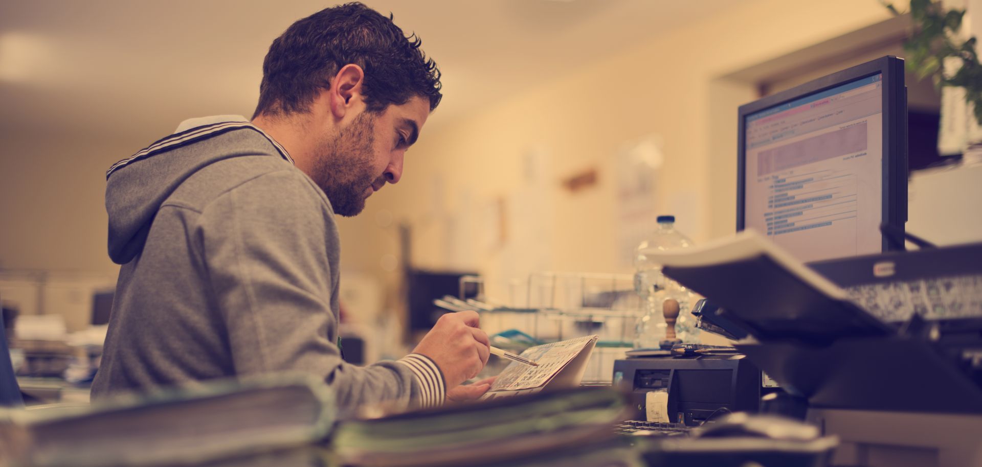 In this photograph, a man works at his computer in an office. Companies need to guard against industrial espionage by one-hit wonders and low-key spies.