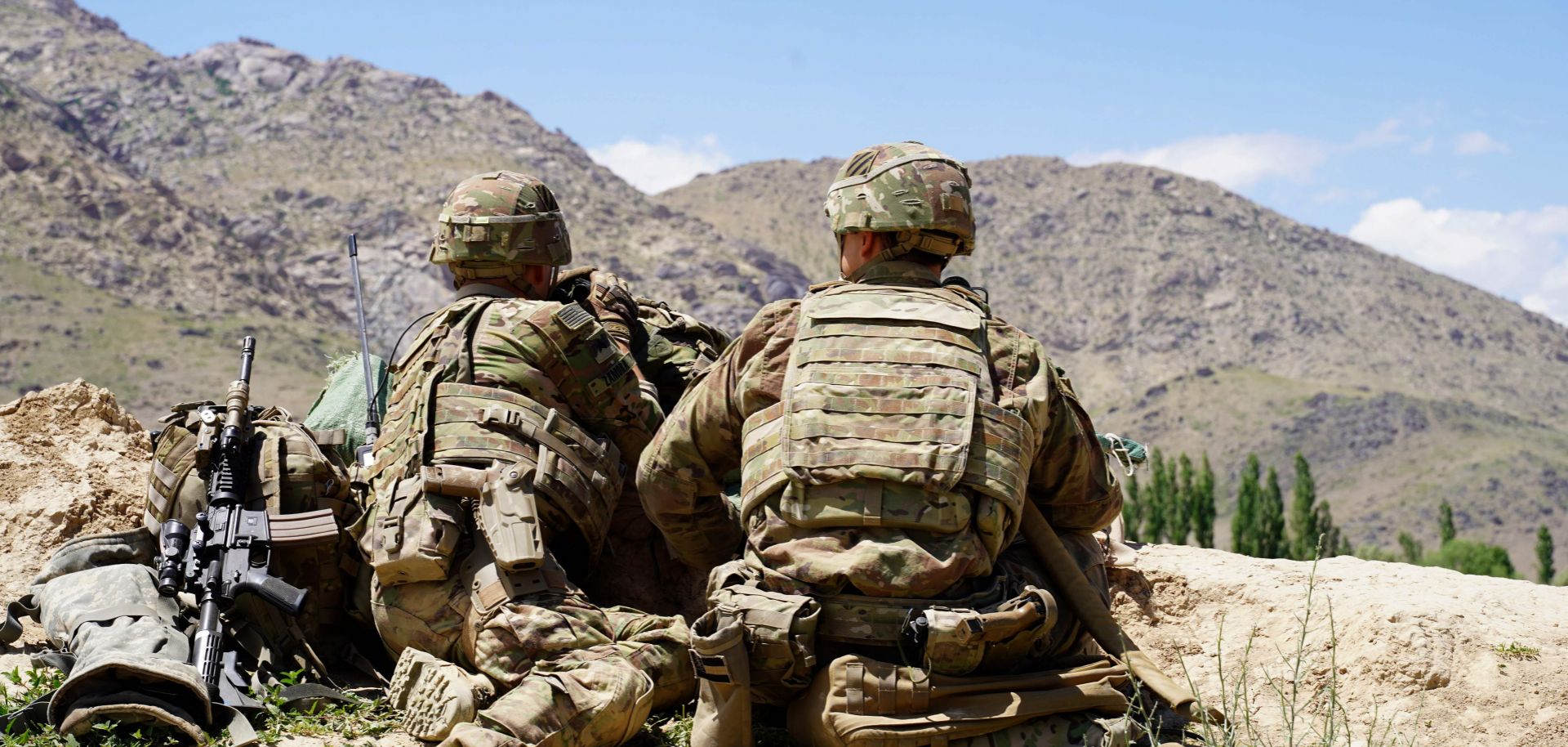 U.S. soldiers look out over the hillsides of an Afghan army checkpoint in Afghanistan's Wardak province on June 6, 2019.