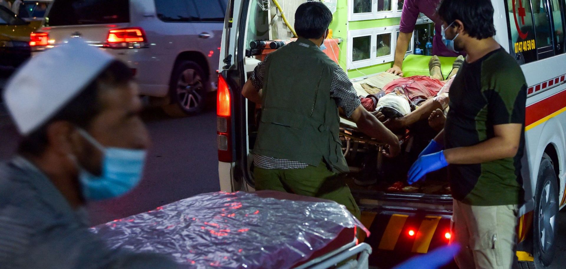 Medical staff bring an injured man to a hospital after a deadly militant attack Aug. 26, 2021, outside Hamid Karzai International Airport in the Afghan capital of Kabul.