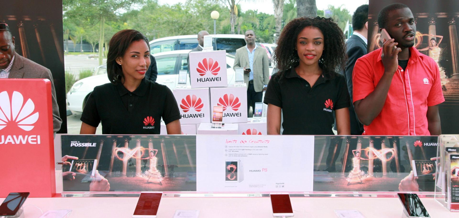 Employees introduce cellphones during a show by Chinese tech firm Huawei in Lusaka, Zambia, during April 2016.