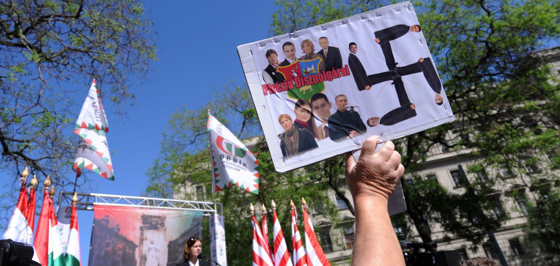 An anti-demonstrator lifts a home-made picture with a Swastika and photos of the party leaders and representatives of the nationalist party of the Hungarian Parliament.