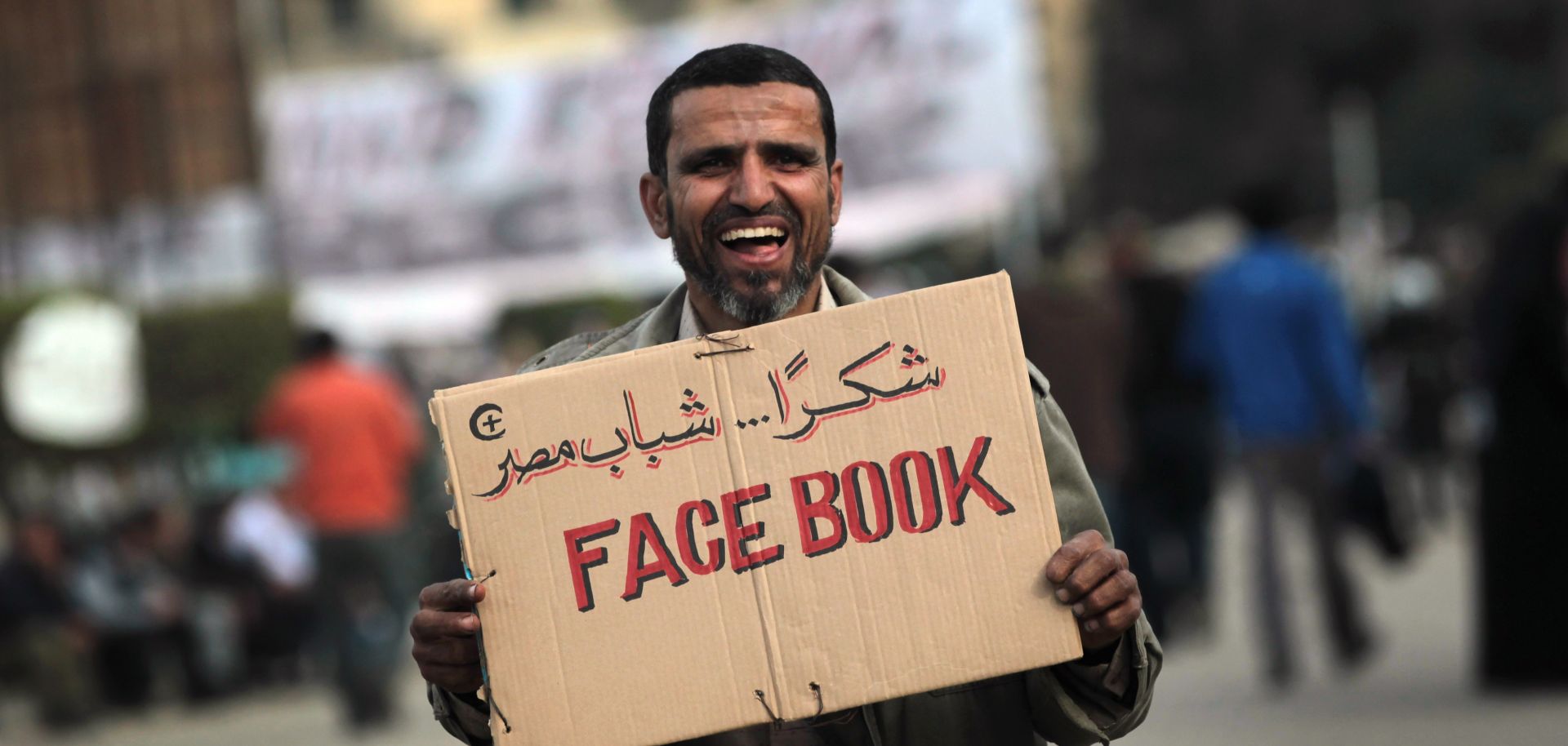 An anti-government demonstrator holds a sign during clashes on February 3, 2011 in Cairo, Egypt.