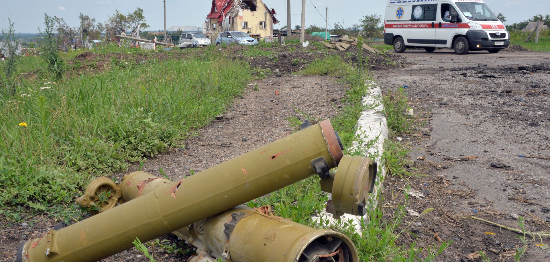 Tubes of portable anti-tank guided missiles lay near a parked ambulance.