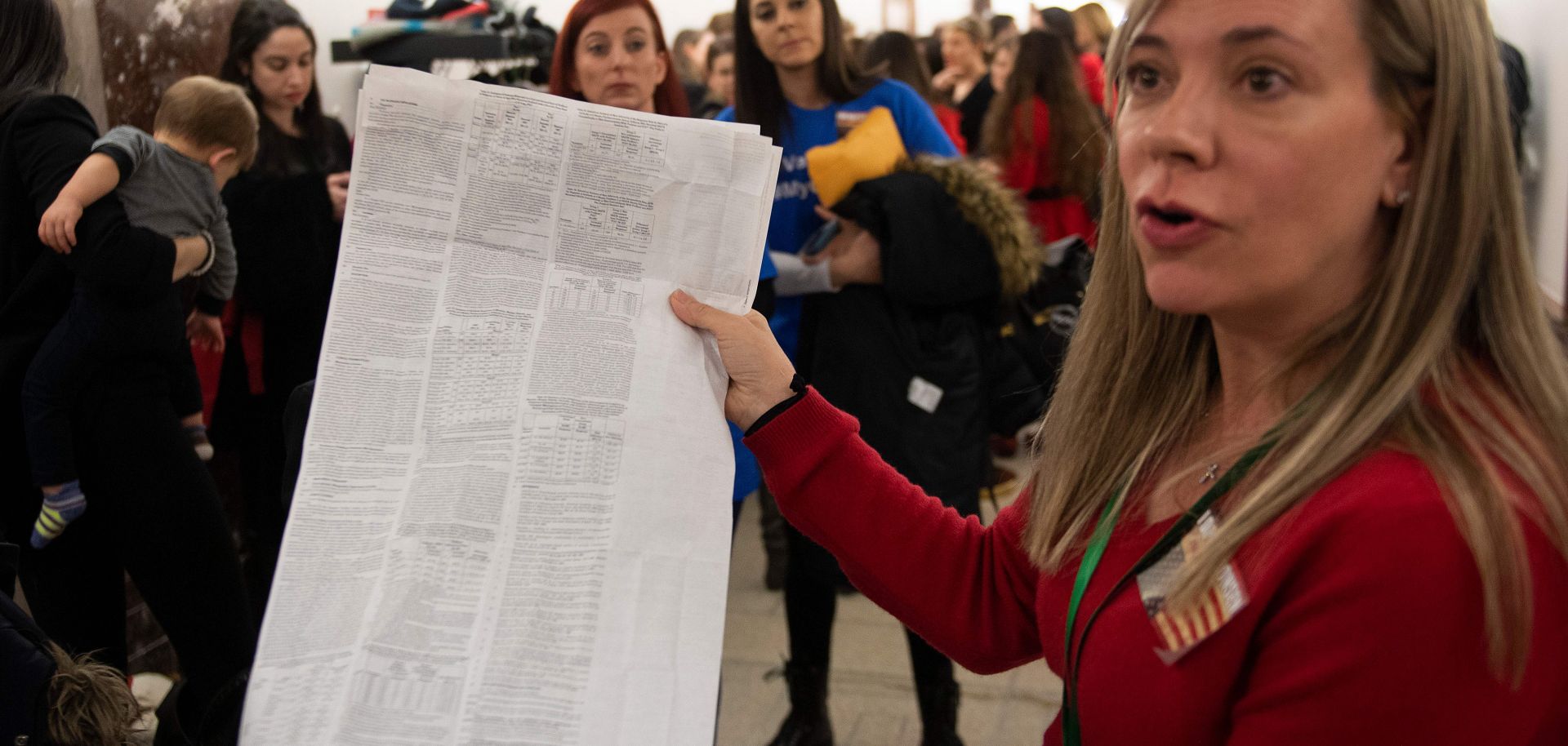 An anti-vaccination parent holds up a prescription document as she waits for a hearing in March 2019 in Washington.