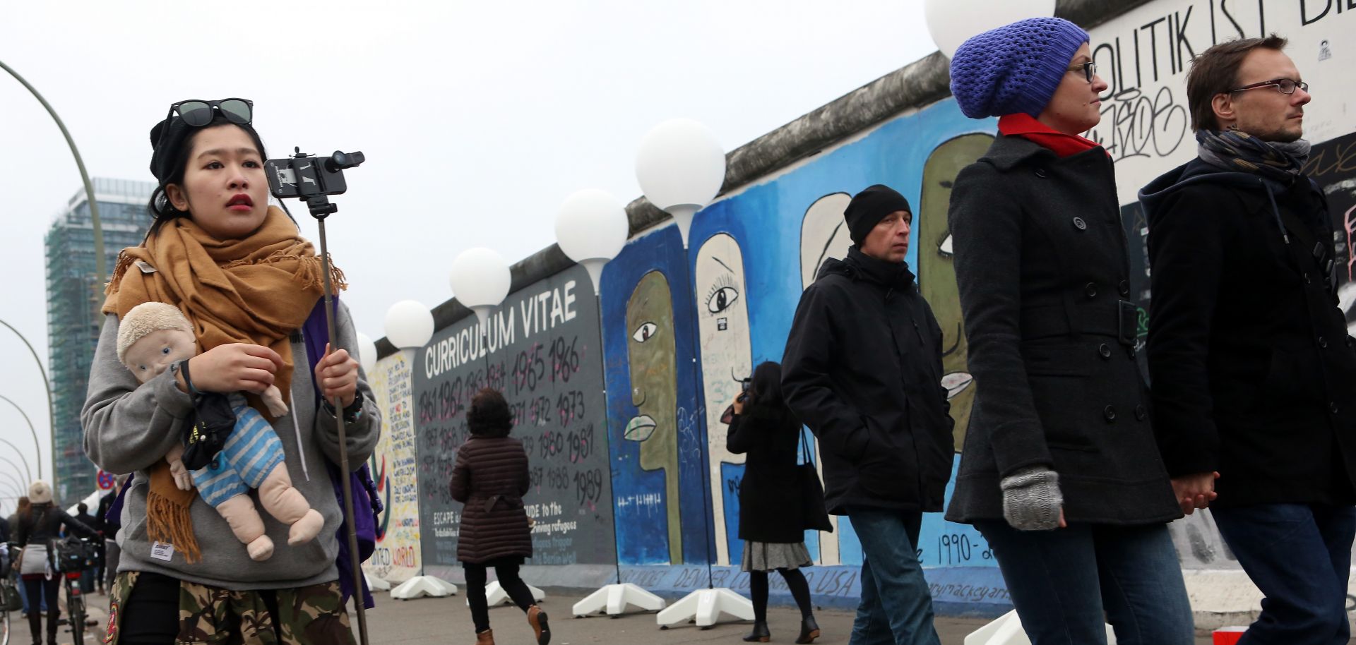 Visitors walk by East Side Gallery section of the former Berlin Wall during celebrations for the 25th anniversary of the fall of the wall that partitioned Germany during the Cold War, Nov. 9, 2014.