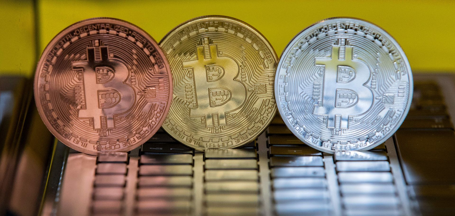 Physical representations of Bitcoin tokens, a digital currency, stand on a computer at a shop in Tel Aviv, Israel.