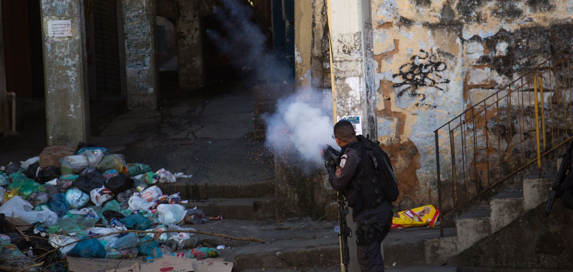 A policeman fires into a building during a protest over the killing of a bystander in Rio de Janeiro during August 2019.