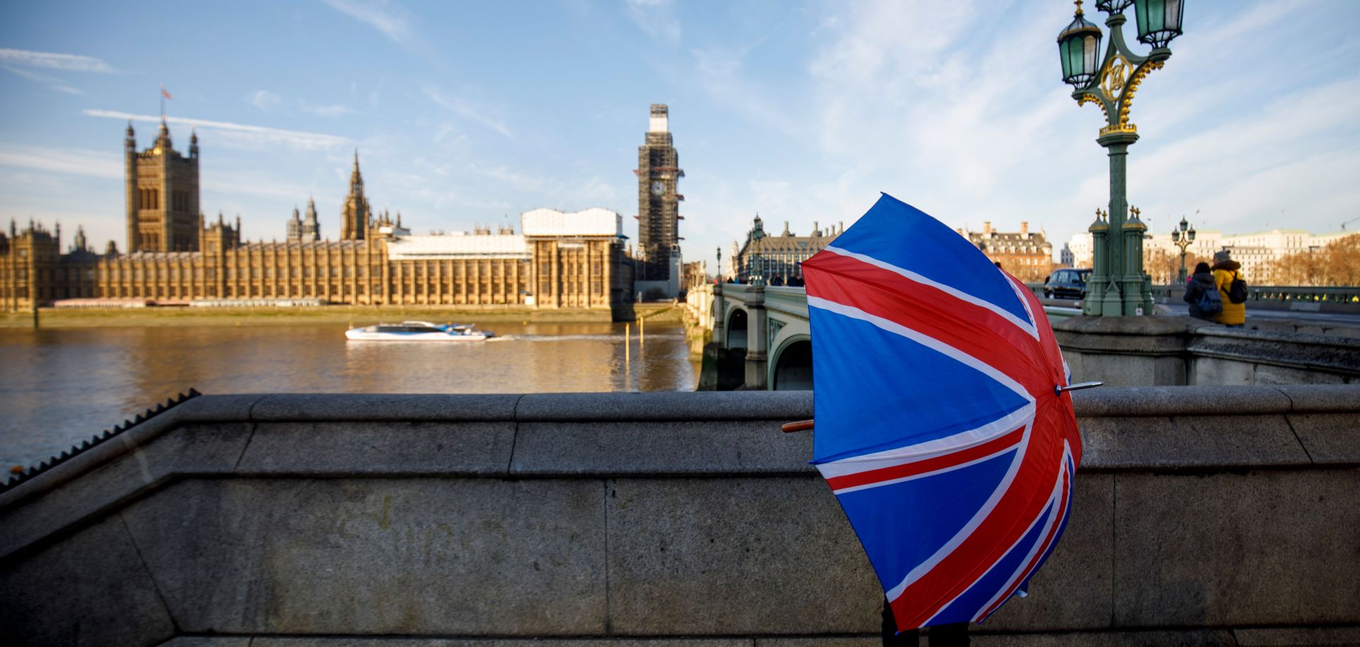 A souvenir stall holder opens a Union Flag umbrella as he arranges his stock opposite the Houses of Parliament on the southern bank of the River Thames in central London.