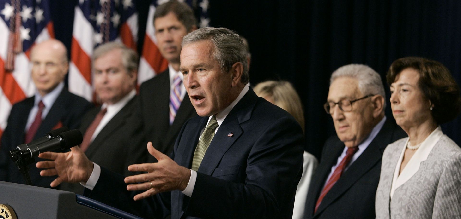 In this 2005 file photo, former U.S. President George W. Bush talks about the Central America-Dominican Republic Free Trade Agreement in Washington, joined by former Cabinet officials who supported the trade deal.