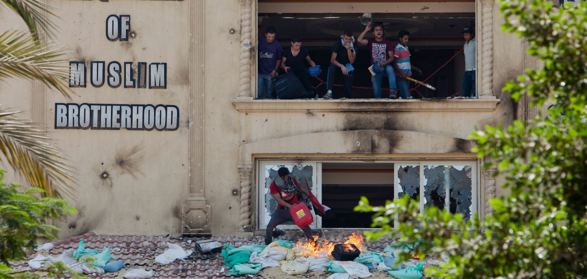 Protestors shout from the windows of the headquarters of Egypt's Muslim Brotherhood.