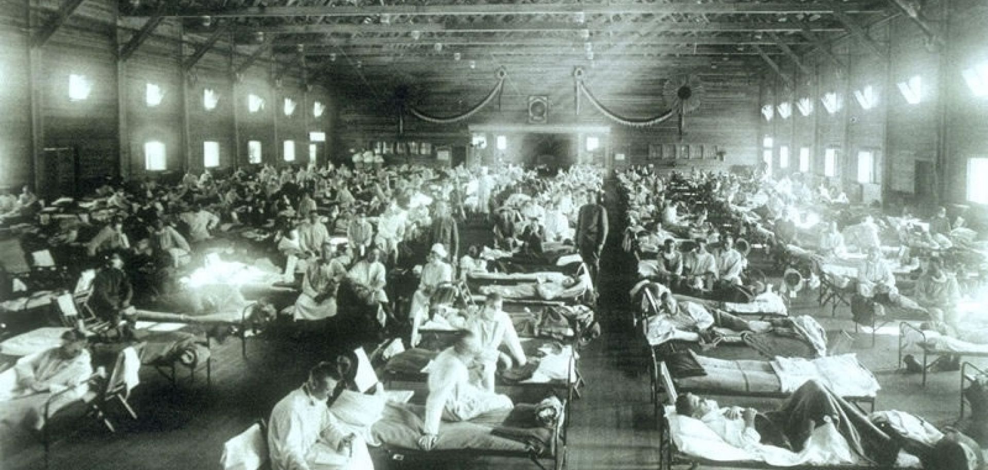 An emergency hospital with rows and rows of sick patients in hospital beds at Camp Funston during the 1918 flu pandemic. 