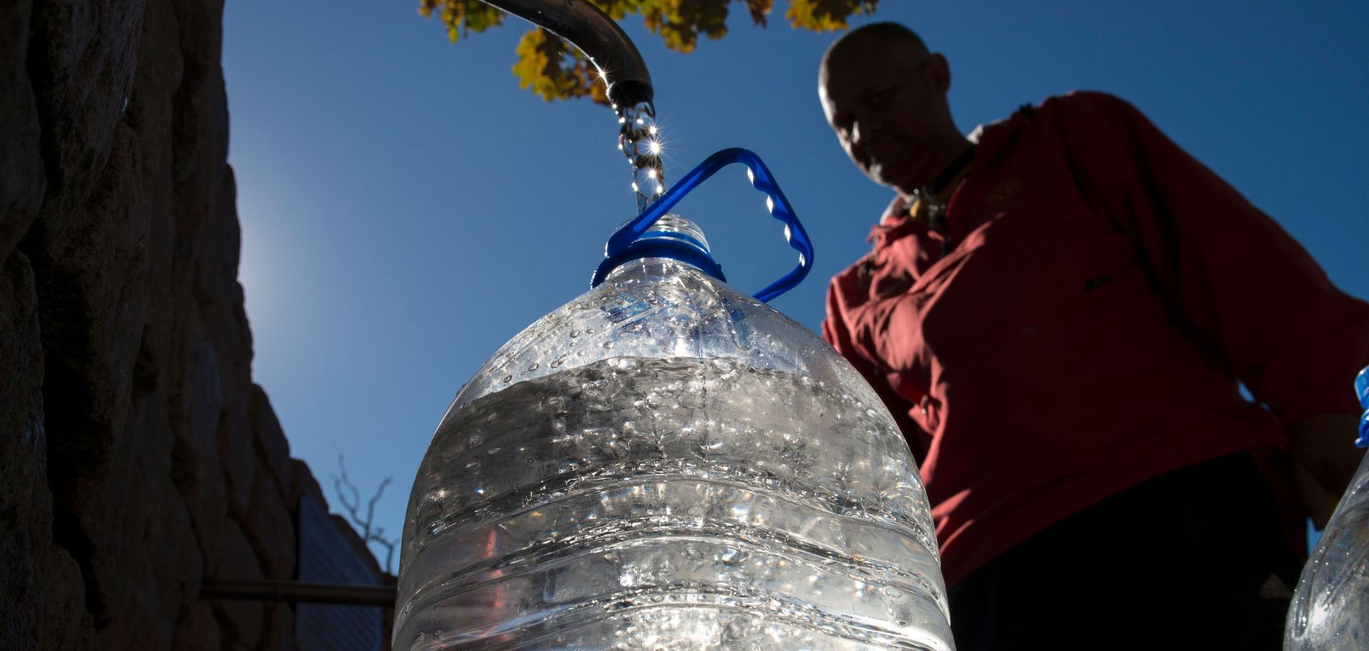 A man fills a plastic jug with drinking water from a spring-fed tap in Cape Town, South Africa. Prolonged drought conditions have put the city in danger of running out of water.
