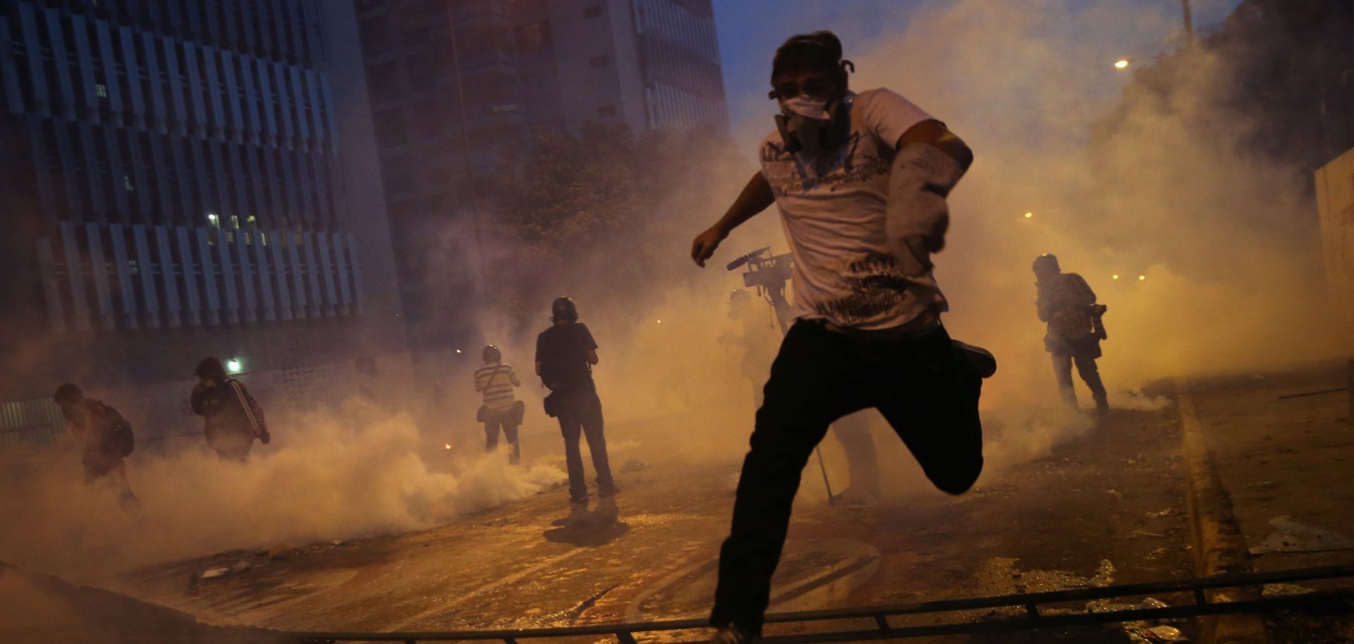 Protesters run from tear gas during an anti-government demonstration on during February in Caracas, Venezuela. A confrontation between government elites and a dissident faction of the ruling party is threatening to balloon into a wider conflict.