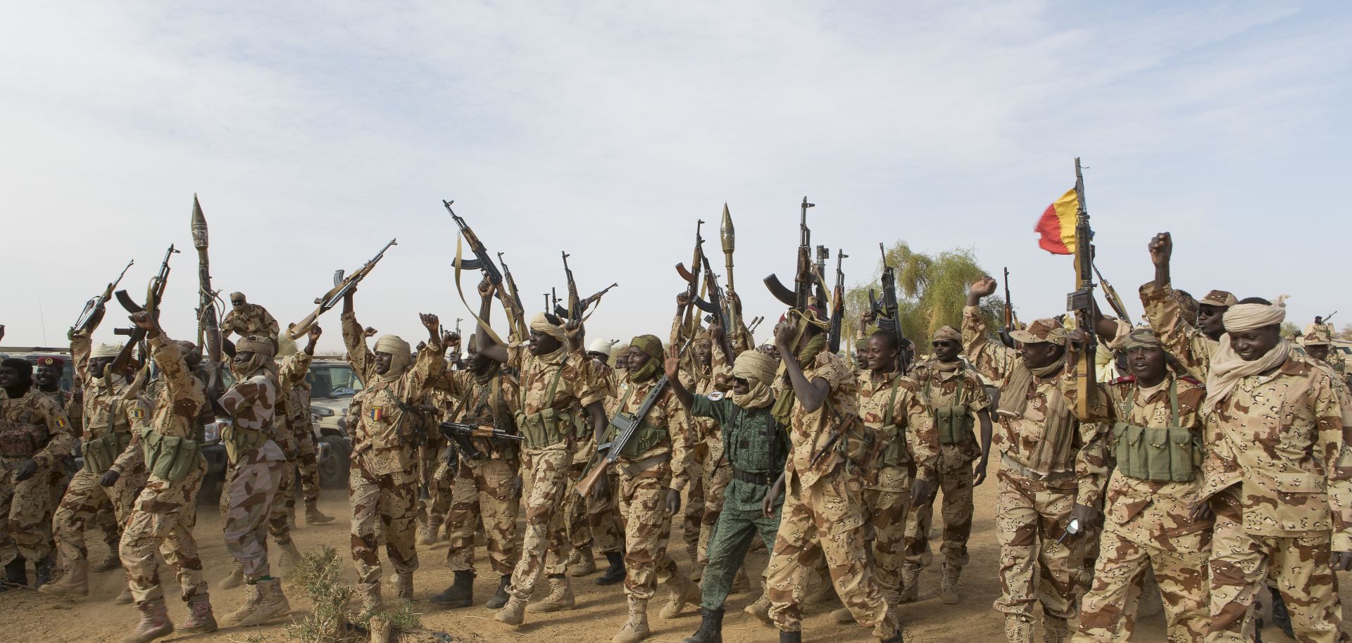 Members of the Chadian Army raise their weapons.