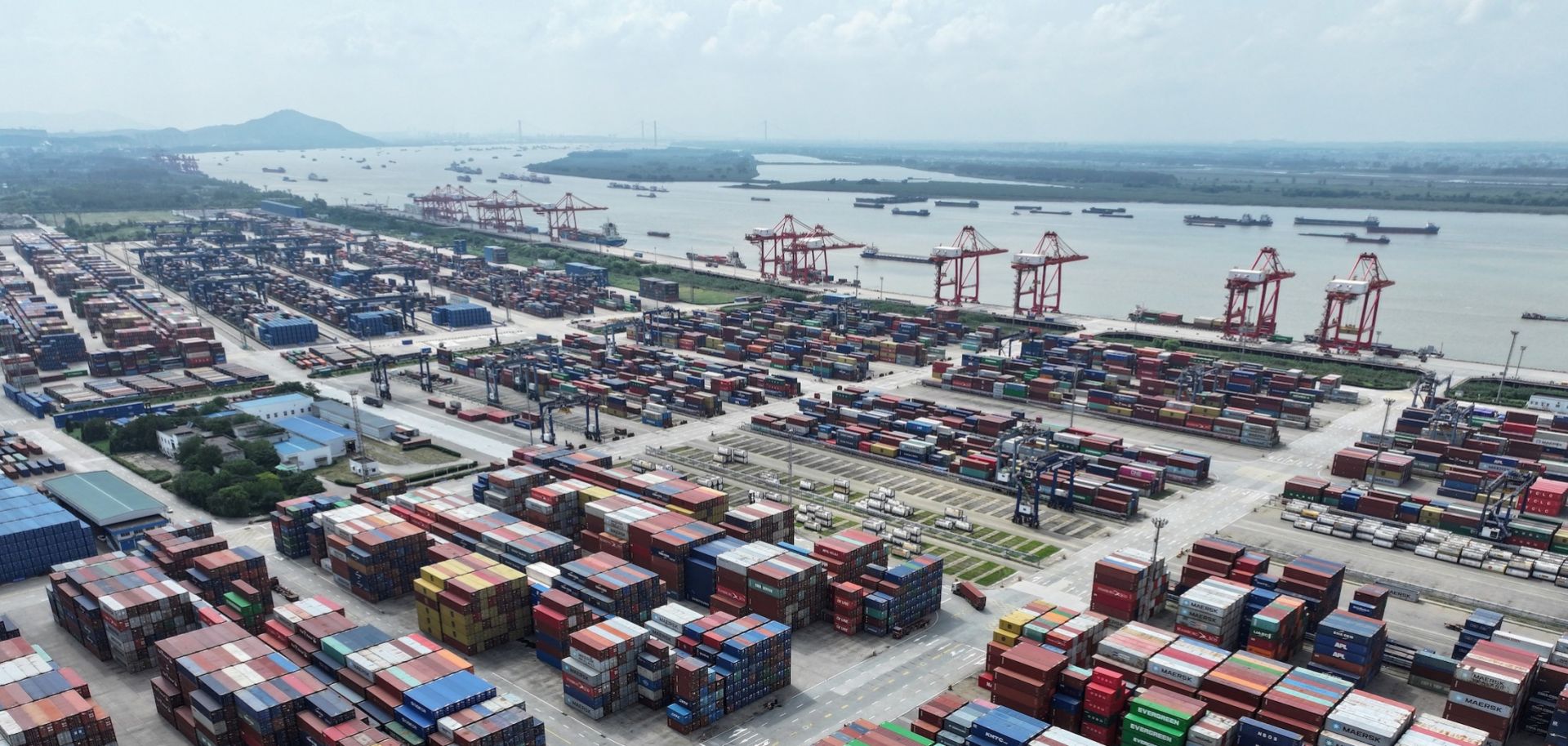 A truck drives between shipping containers at Nanjing port in China's eastern Jiangsu province on Aug. 6, 2023.