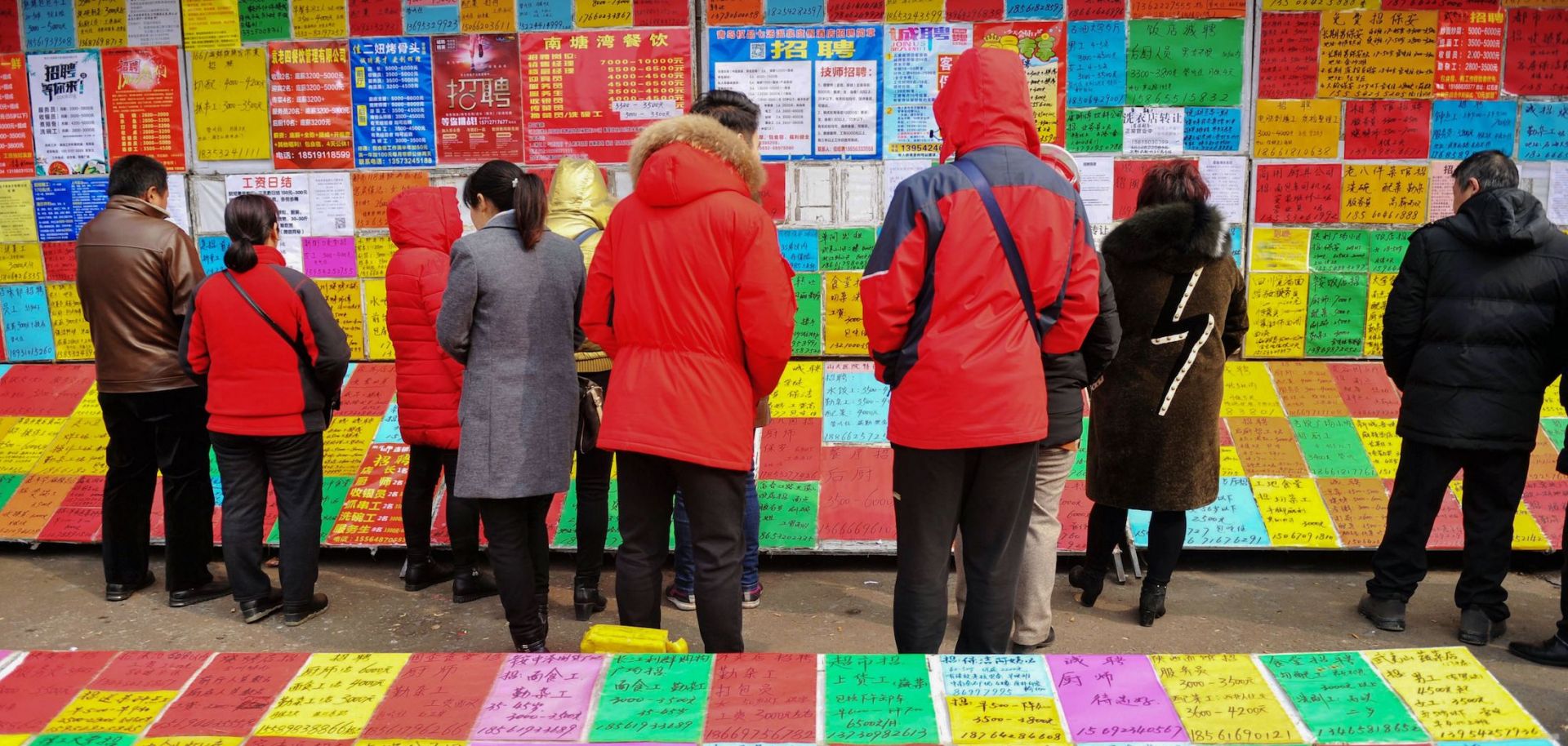 This picture taken on Feb. 20, 2019, shows job seekers looking at employment postings at a recruitment fair in Qingdao in China's eastern Shandong province.