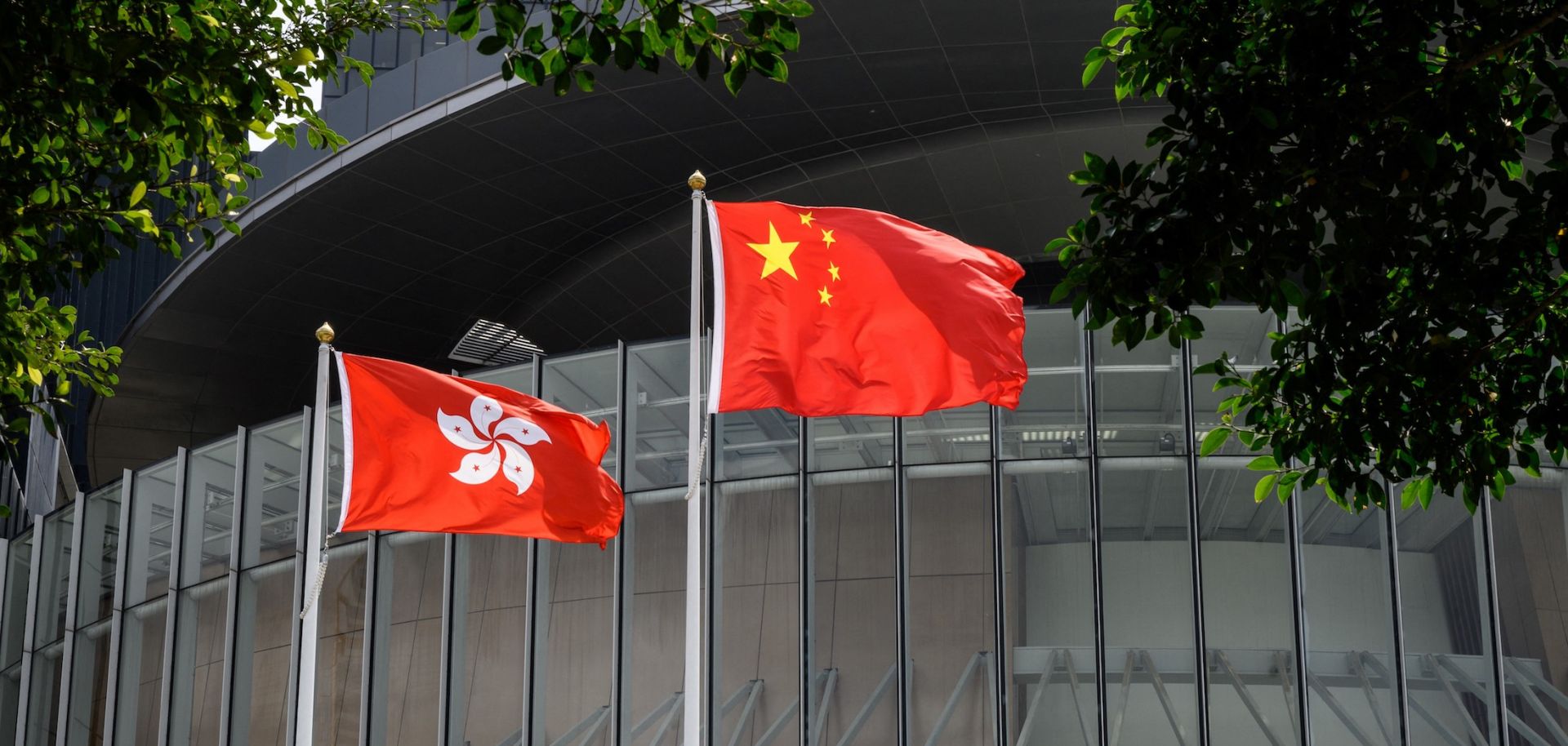 Flags of China (C) and Hong Kong (L) on March 30, 2021, outside the Legislative Council complex in Hong Kong.