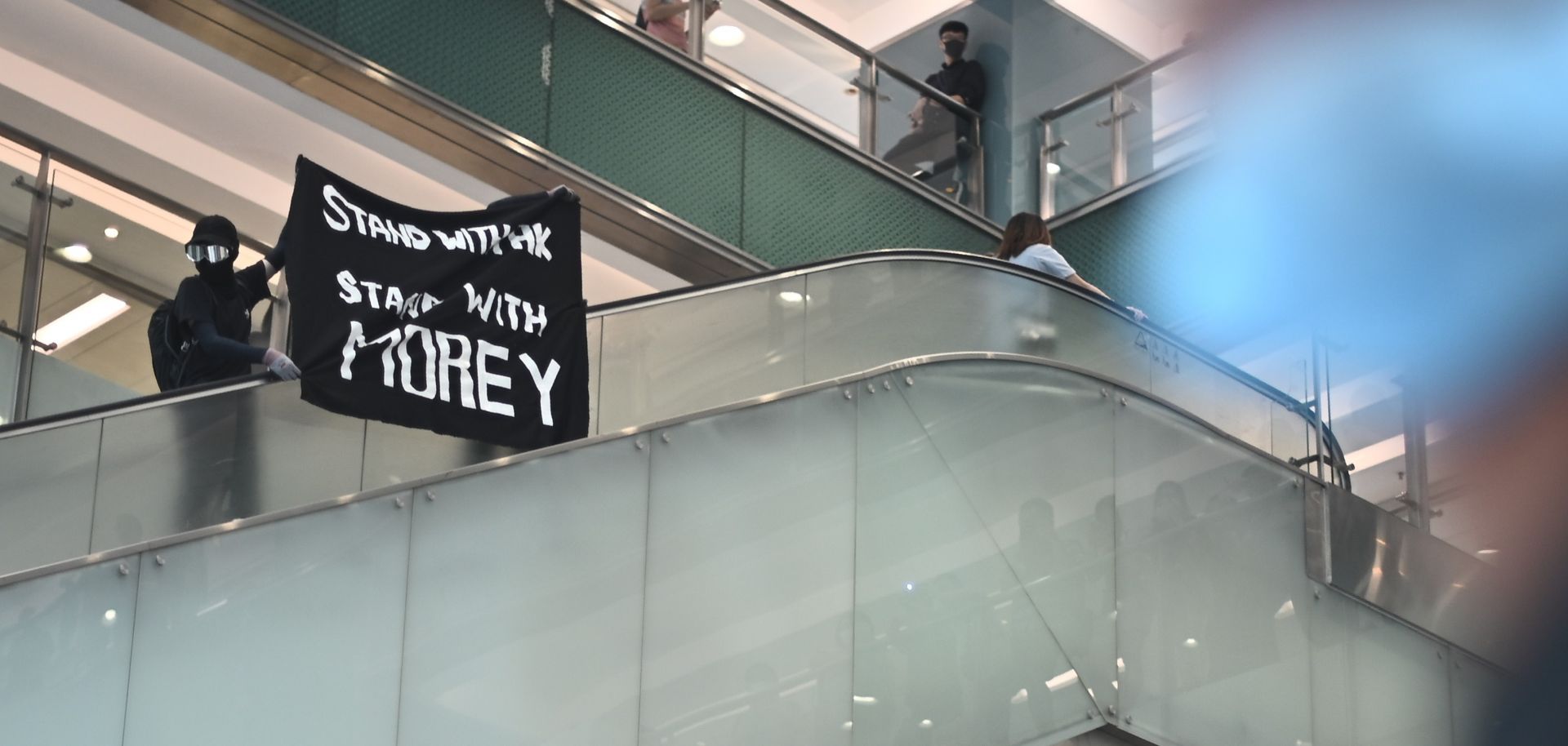 This photo shows a protester in Hong Kong waving a banner of support for NBA team executive Daryl Morey.