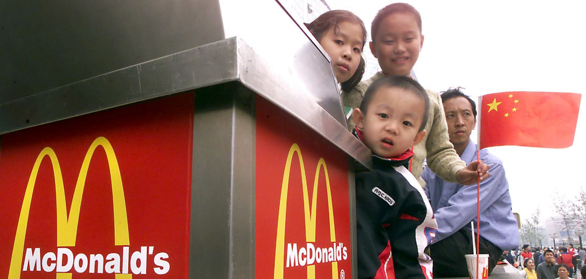 Chinese children peek from behind a trash can at a McDonald's in Beijing in October 2000, the month the United States granted China permanent normal trade relations.