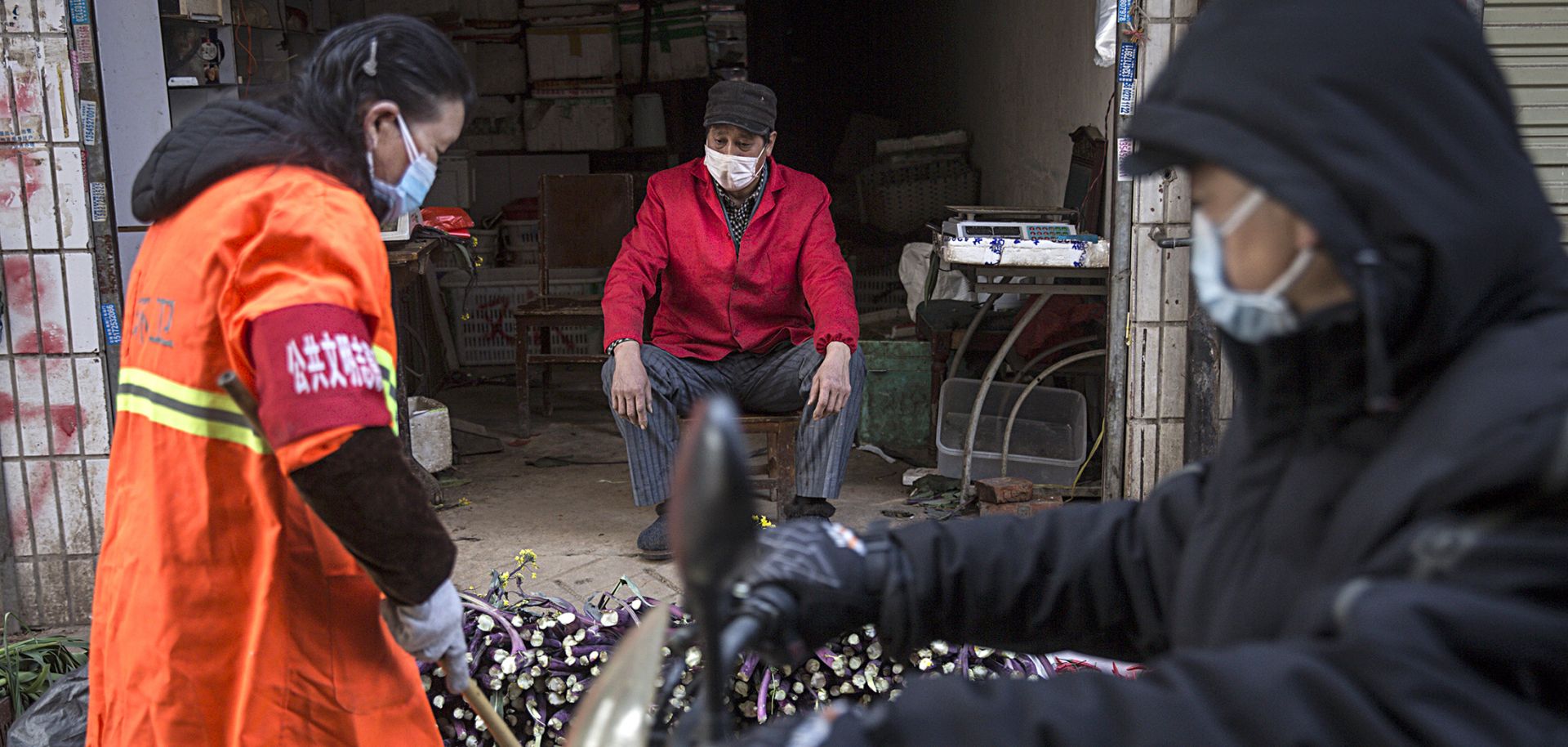 This photo shows a masked vendor and customers of his wares in an alley in Wuhan, China, on January 31, 2020.