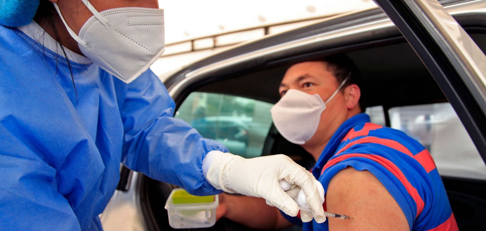 A man receives a dose of a COVID-19 vaccine at a drive-through distribution site in Bogota, Colombia, on April 11, 2021.