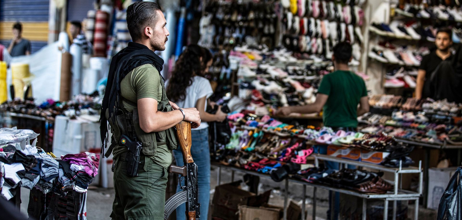 A member of the Kurdish Internal Security Police Force of Asayish stands guard at a market in the northeastern Syrian city of Qamishli on Aug. 5, 2019.