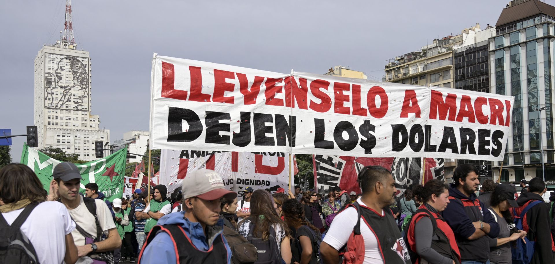 Marching demonstrators hold a banner reading "Take Macri away, leave us the dollars" during a partial strike against the economic policies of the government of Argentina's President Mauricio Macri on April 30, 2019.