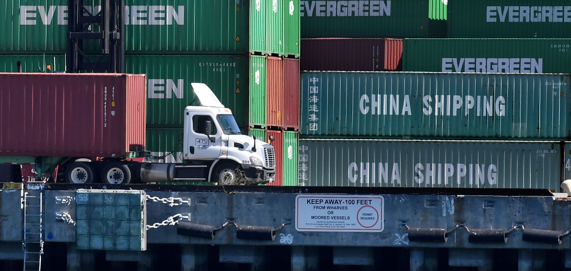 Dock workers unload shipping containers with goods imported from China and elsewhere at the Port of Long Beach in Los Angeles.