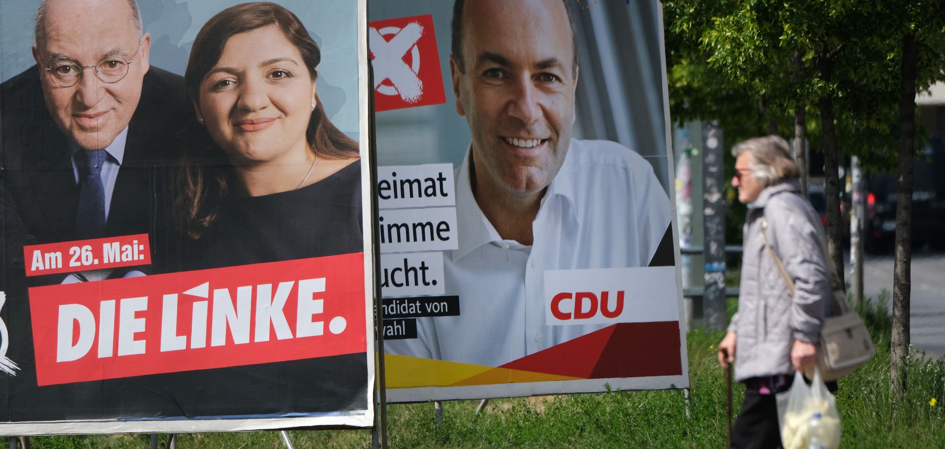 A pedestrian passes election campaign posters of the left-wing Die Linke and of the center-right German Christian Democrats on May 13, 2019, in Berlin.