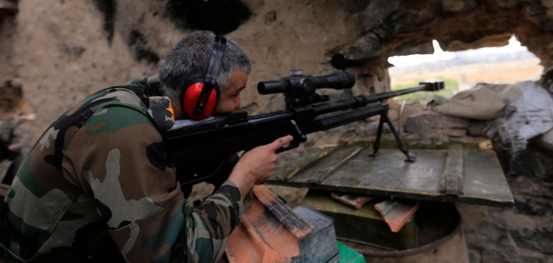 A picture taken on April 29, 2018, during a government guided tour in Damascus' southern al-Qadam neighborhood shows Syrian army sniper taking aim at Islamic State positions in Yarmuk, a Palestinian refugee camp on the edge of the capital. 