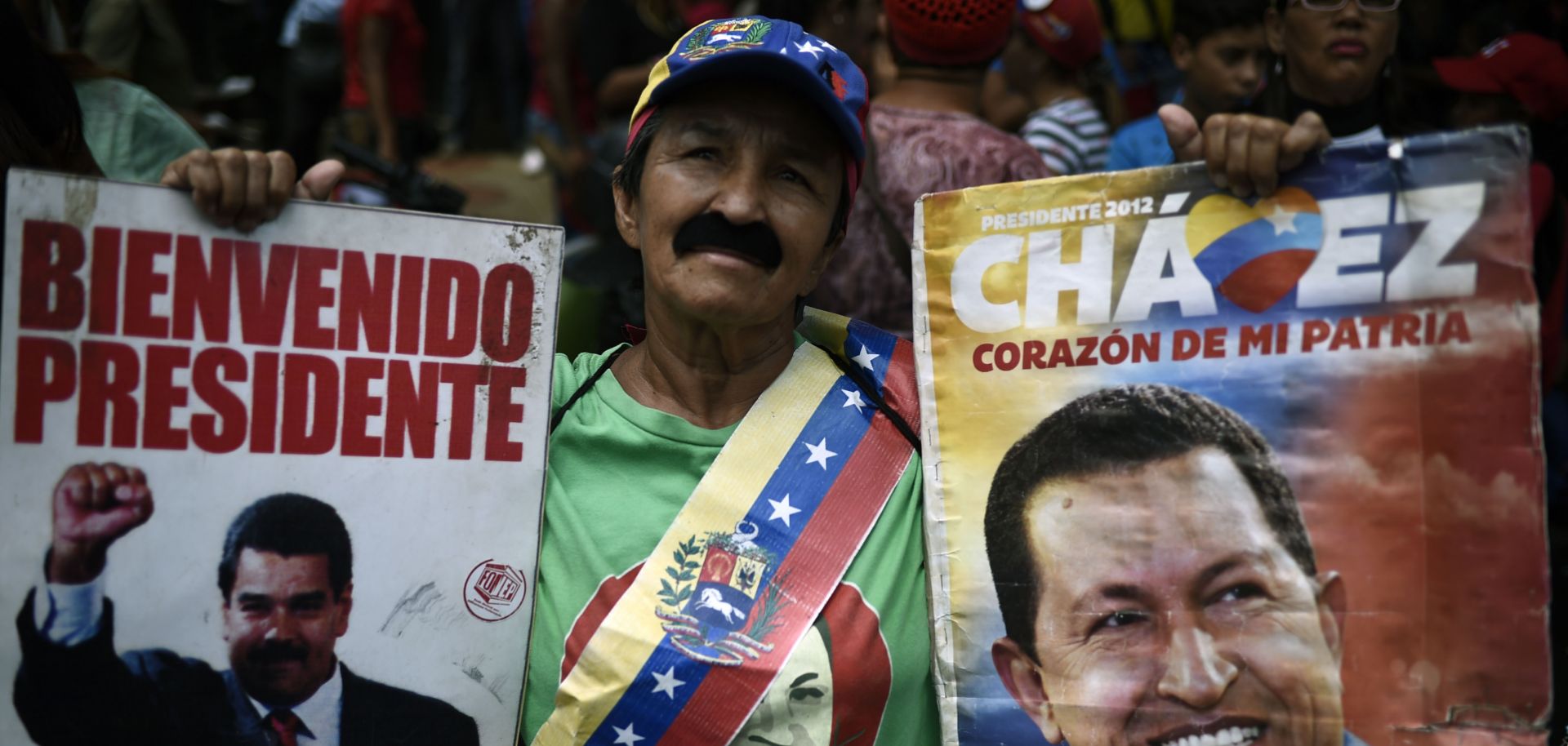 A citizen shows his support for Venezuela's current president, Nicolas Maduro, (pictured in the poster on the left), as well as former President Hugo Chavez.  