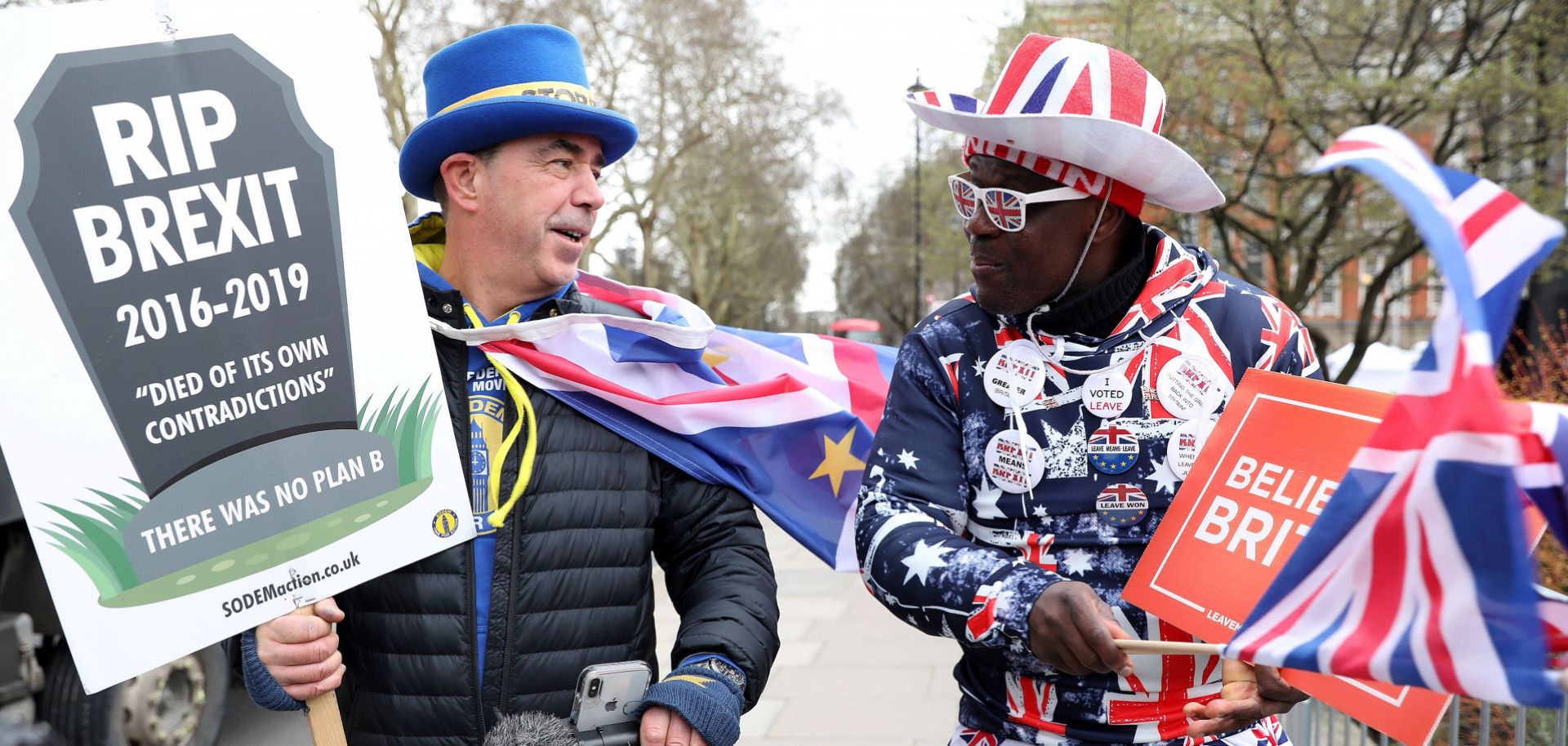 Brexit opponent Steve Bray, left, and Brexit supporter Joseph Afrane walk near the Houses of Parliament in London on March 13, 2019.