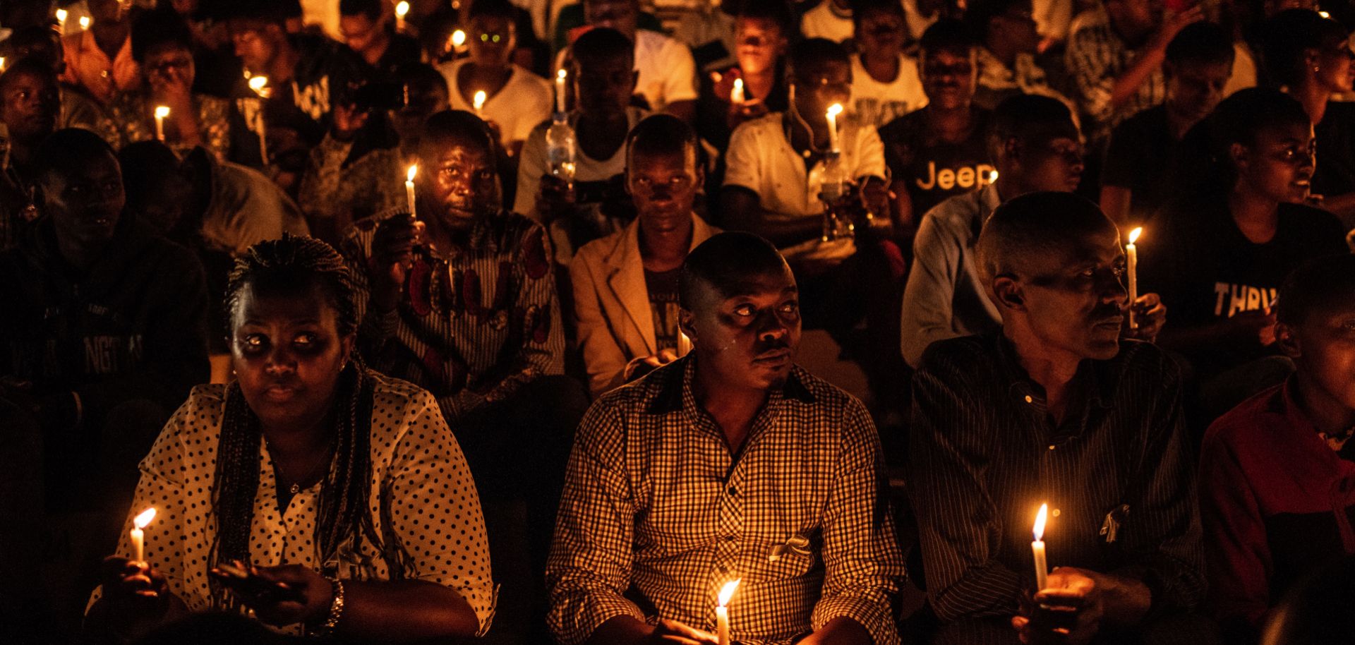 People hold candles during a ceremony commemorating the 25th anniversary of the Rwandan Genocide on April 7, 2019, at the Amahoro Stadium in Kigali. 