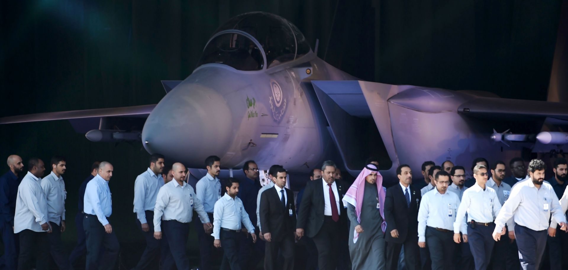 Saudi air force officers and technical staff walk past an advanced F-15SA fighter jet during a ceremony on Jan. 25, 2017 in Riyadh marking the 50th anniversary of the creation of the King Faisal Air Academy.