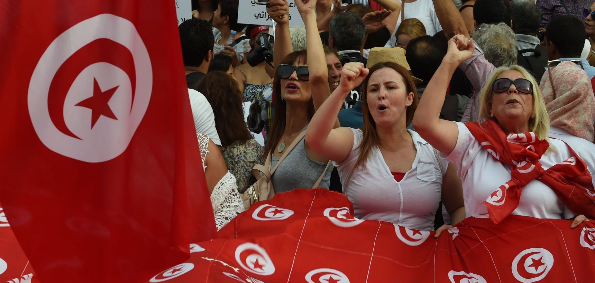Tunisian women chant slogans and wave their national flag during a demonstration on Aug. 13, 2018, to mark Tunisia's Women's Day and to demand equal inheritance rights for men and women.