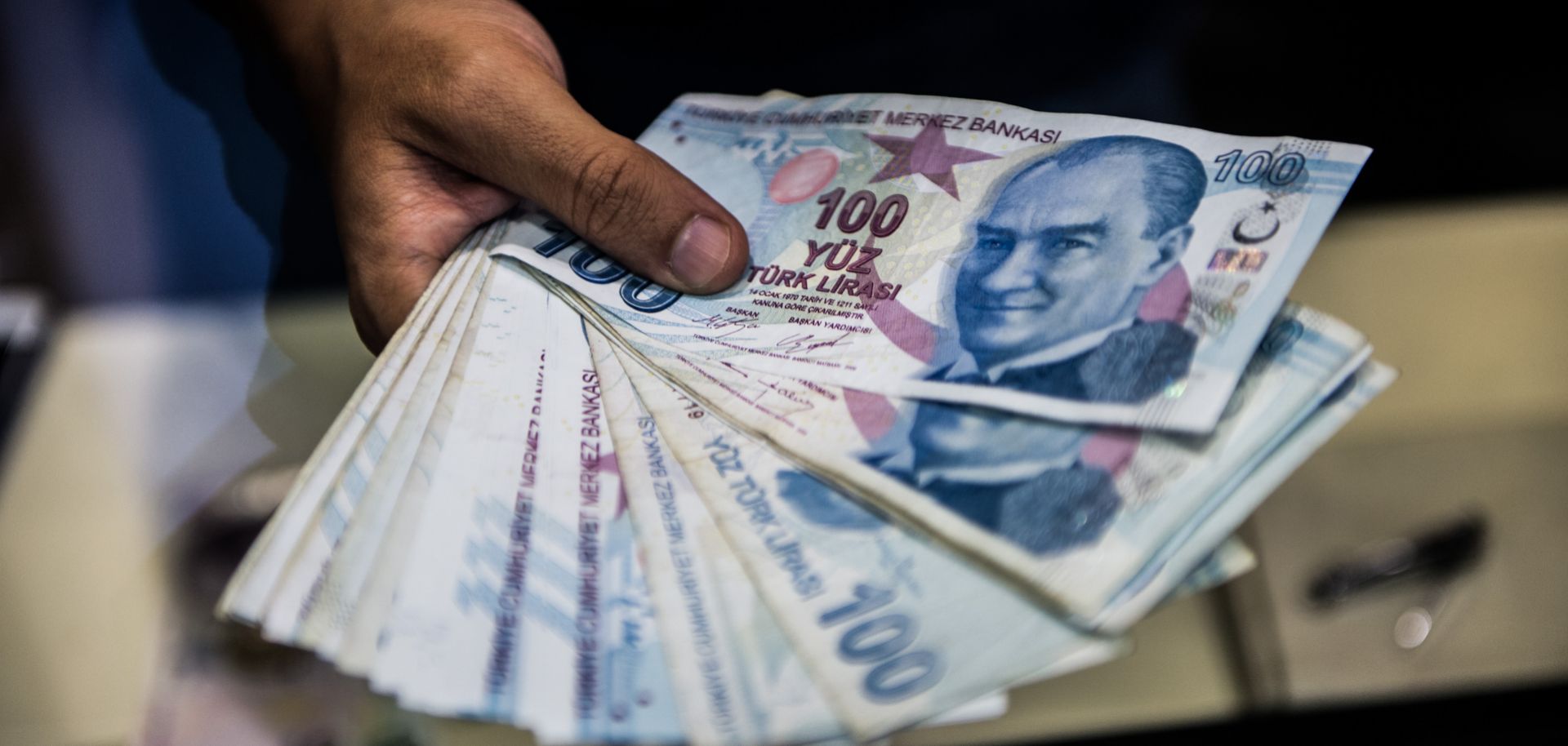A teller holds Turkish lira banknotes at a currency exchange office in Istanbul on Aug. 13, 2018.