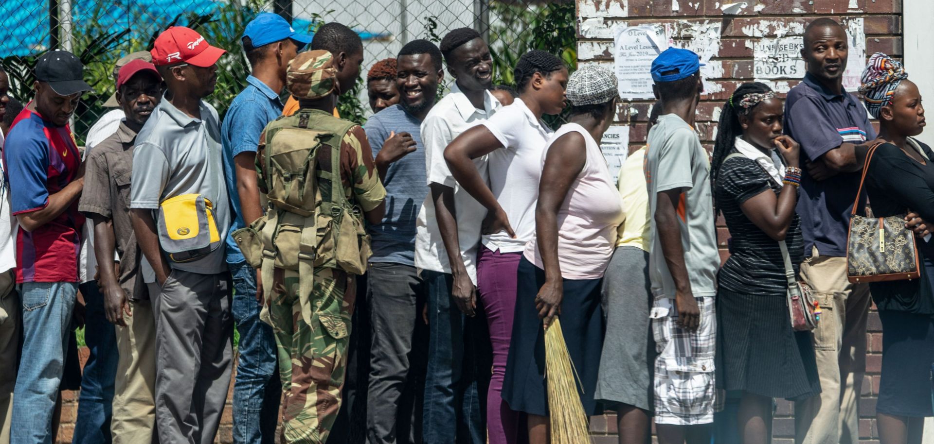 A Zimbabwean soldier watches shoppers lining up in Bulawayo on Jan. 17, 2019.