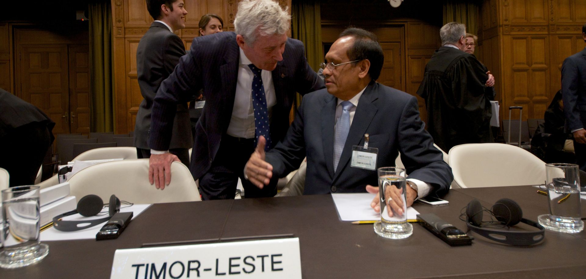 Timor-Leste's Foreign Affairs minister Jose Luis Gutierrez (R) speaks with Australian lawyer Bernard Collaery (L) during a session of the International Court of Justice in 2014. Collaery faces prosecution in Australia for disclosing information about the country's intelligence services in a case worthy of a spy novel.