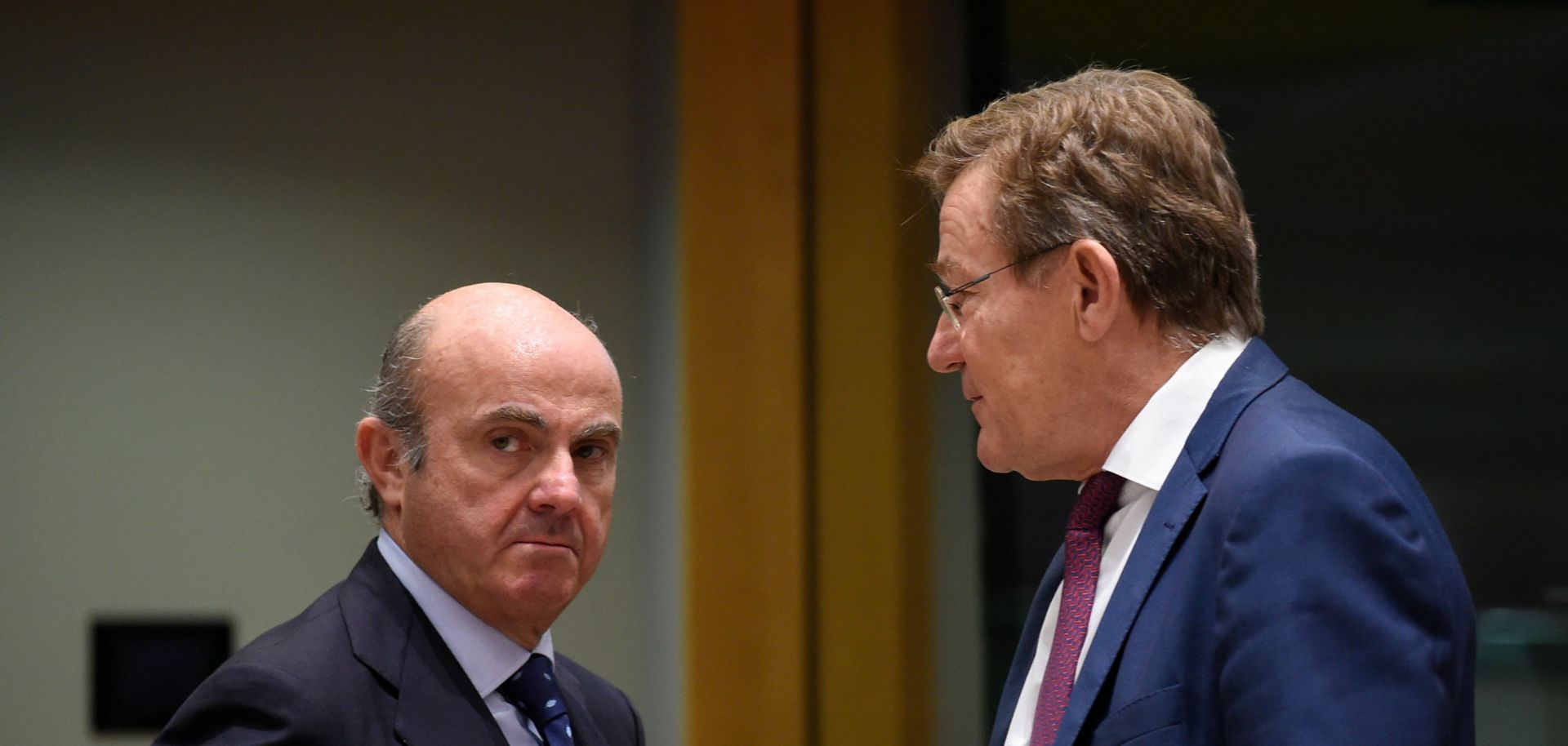 Spanish Economy Minister Luis de Guindos (L) talks with Belgian Finance Minister Johan Van Overtveldt during a meeting in Brussels on Feb. 20.